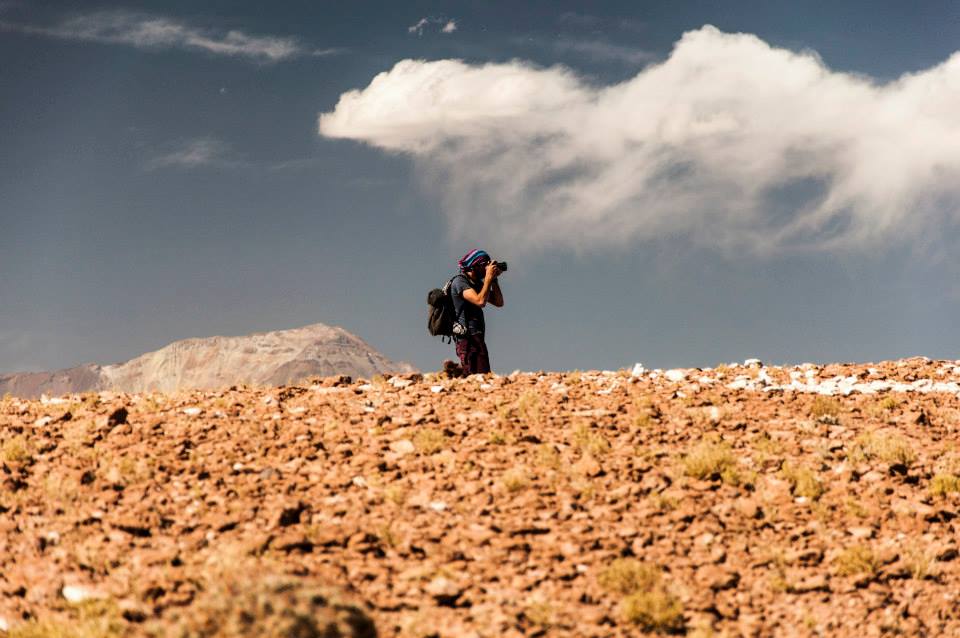 Alumno Arquitectura UDD hincado tomando una foto en terreno